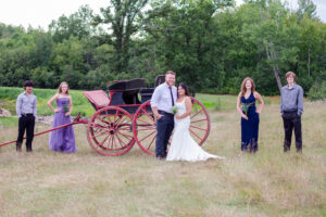 Bridal party in front of antique horse carriage in pasture overlooking Pleasant Pastures Weddings and Events in Central Minnesota