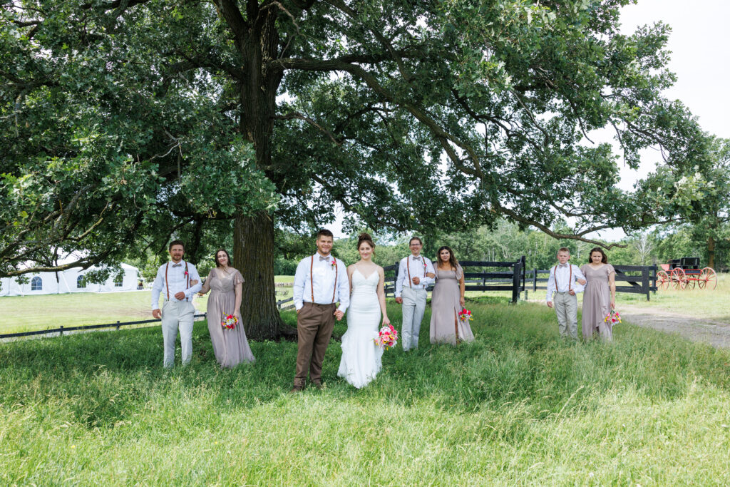 Outdoor wedding venue at Pleasant Pastures Events in Central MN featuring giant old oak trees, outdoor ceremony site with reception tent and concrete dance floor while enjoying the grain bin bar