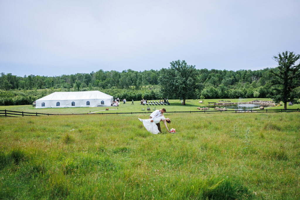 Outdoor wedding venue at Pleasant Pastures Events in Central MN featuring giant oak trees, ponds, outdoor ceremony site, reception tent, concrete dance floor, grain bin bar, garden like setting, rustic outdoor