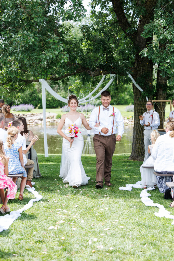Outdoor wedding venue at Pleasant Pastures Events in Central MN featuring giant oak trees, ponds, outdoor ceremony site, reception tent, concrete dance floor, grain bin bar, garden like setting, rustic outdoor