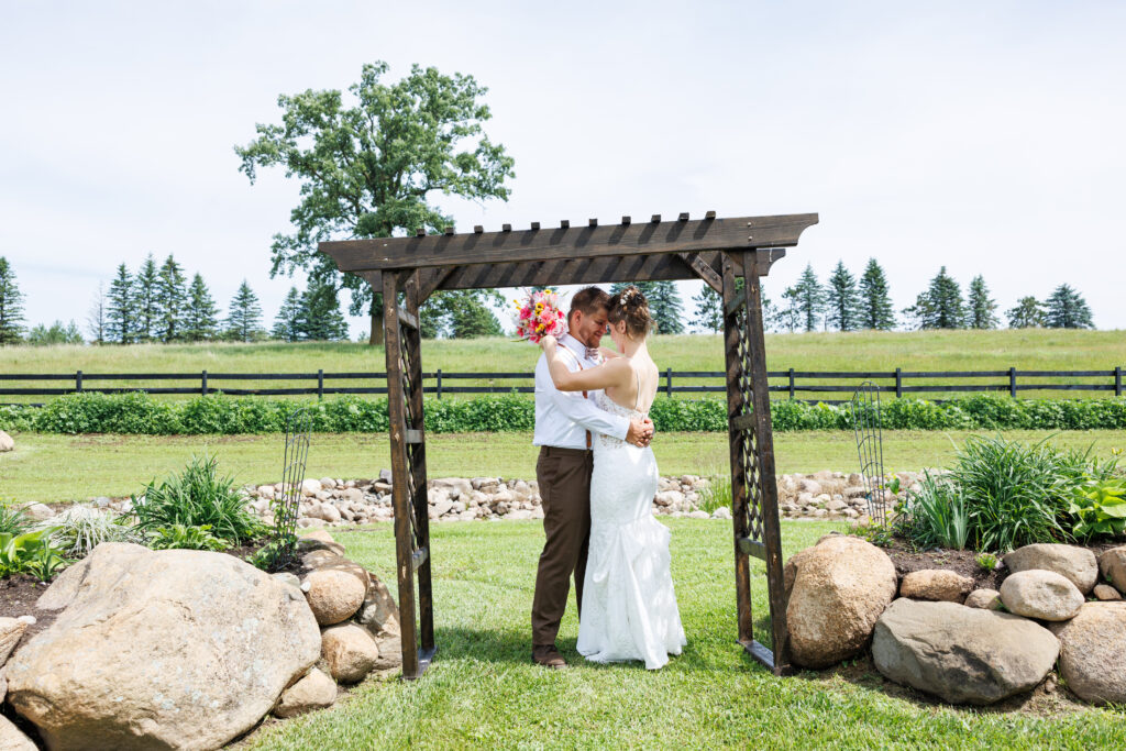 Outdoor wedding venue at Pleasant Pastures Events in Central MN featuring giant oak trees, ponds, outdoor ceremony site, reception tent, concrete dance floor, grain bin bar, garden like setting, rustic outdoor