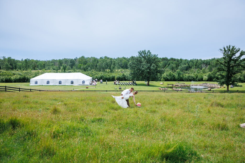 Outdoor wedding venue at Pleasant Pastures Events in Central MN featuring giant oak trees, ponds, outdoor ceremony site, reception tent, concrete dance floor, grain bin bar, garden like setting, rustic outdoor